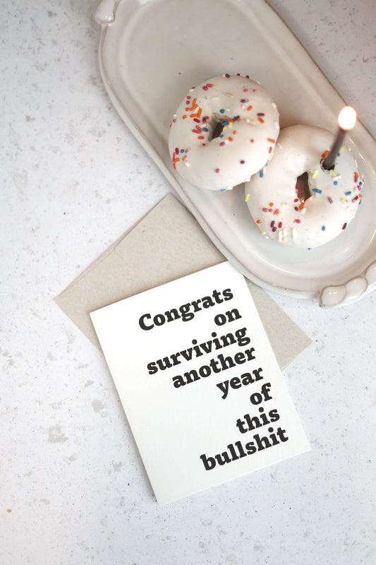 Congrats on surviving another year of this bullsh!t | Greeting card by Gravesco
