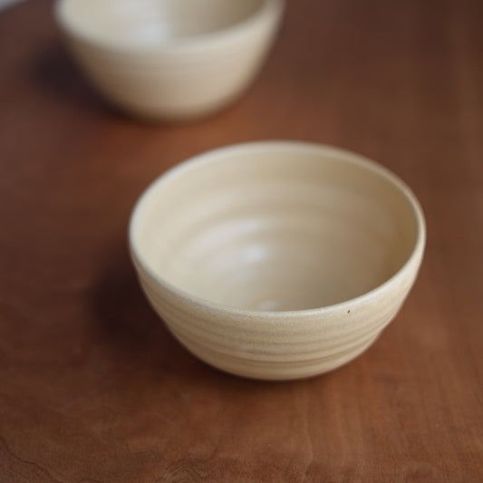 Beige ceramic bowl on a wooden surface