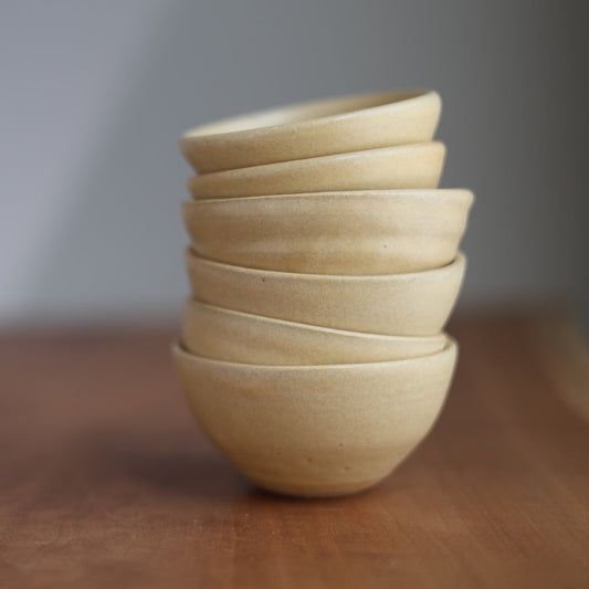 Stack of ceramic bowls on a wooden surface with a blurred background