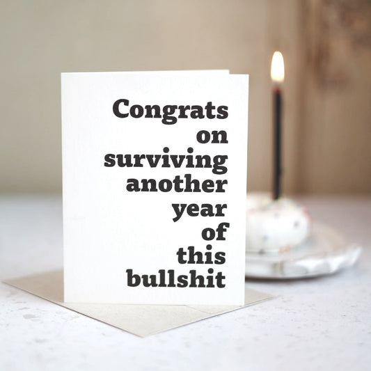Congrats on surviving another year of this bullsh!t | Greeting card by Gravesco