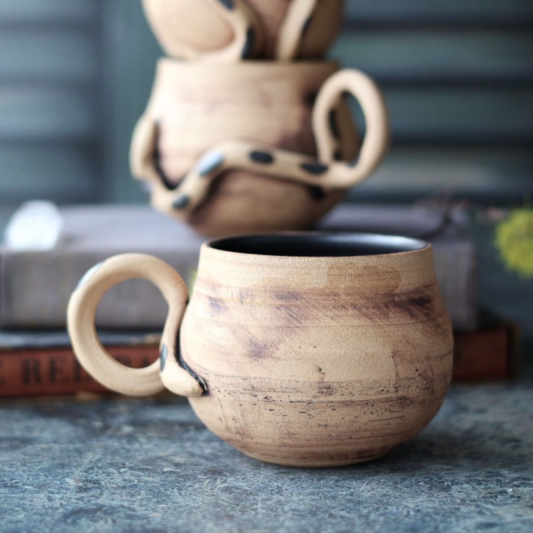 Stack of ceramic mugs on a textured surface with a blurred background