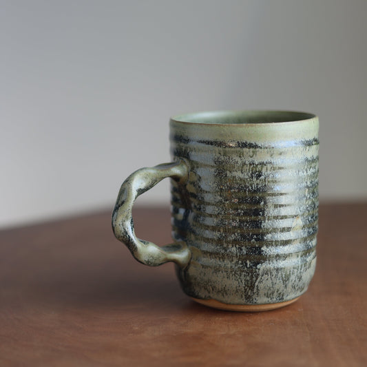 22 oz moss green Ceramic mug on a wooden table with a blurred background