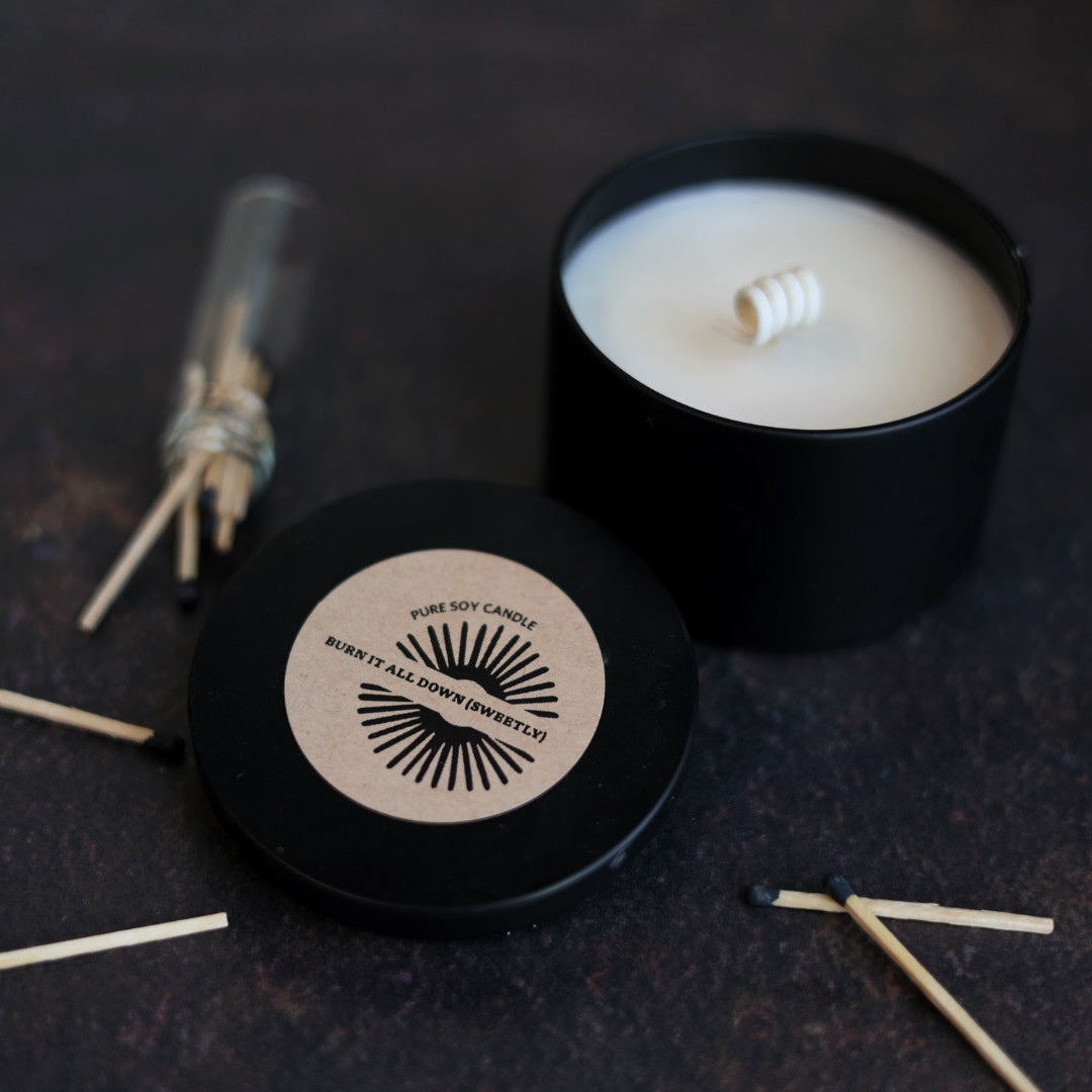 Black candle with matches on a dark surface