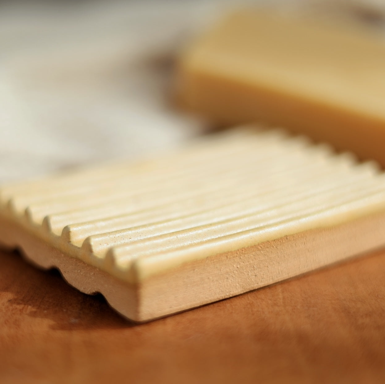 Close-up of a rectangular soap bar with textured surface on a wooden surface.