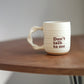 Off White handmade companion mug with 'Don't talk to me' text on a wooden table against a plain background