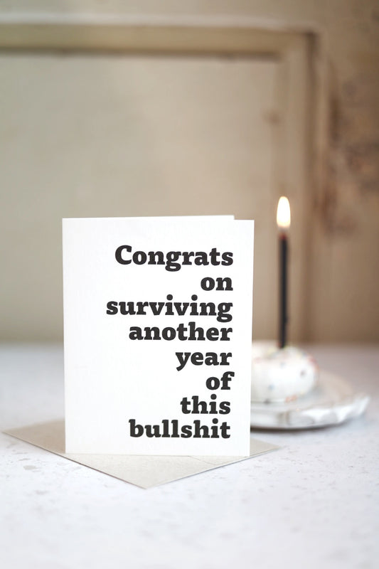 Congrats on surviving another year of this bullsh!t | Greeting card by Gravesco