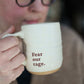 Person holding a mug with 'Fear our rage.' text