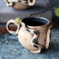 Handmade ceramic mug with unique design on a textured surface