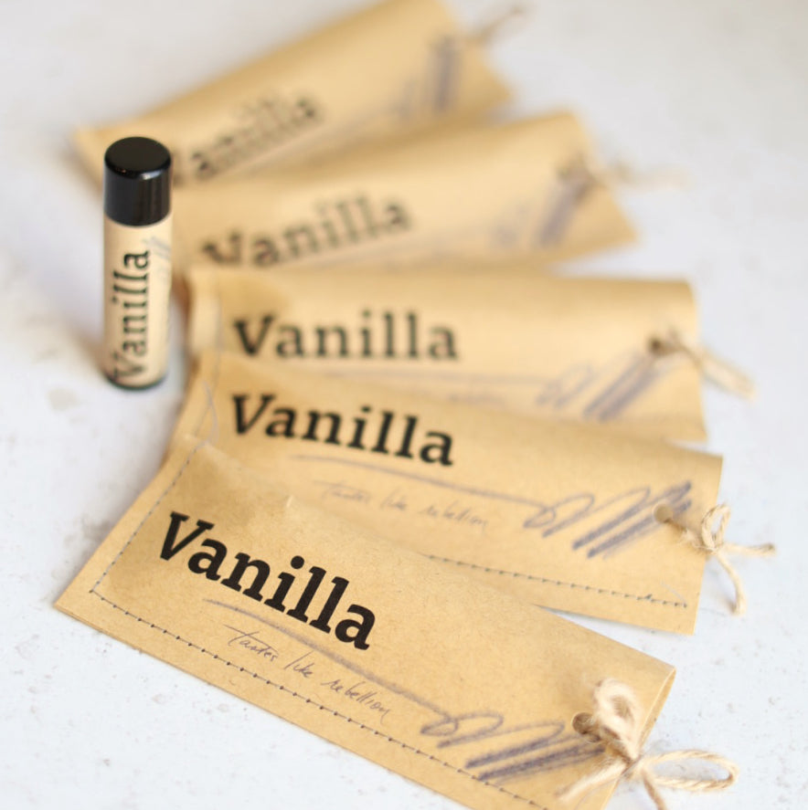 Vanilla-scented lip balms on a white surface