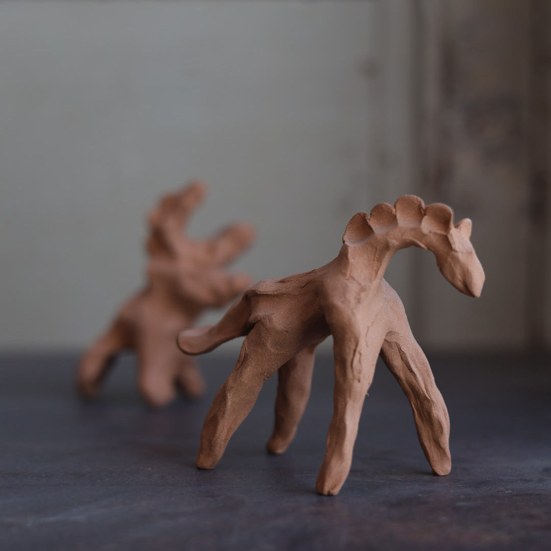 Clay sculpture of a horse on a dark background