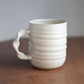 Cream Handmade ceramic jumbo companion mug with a handle on a wooden surface