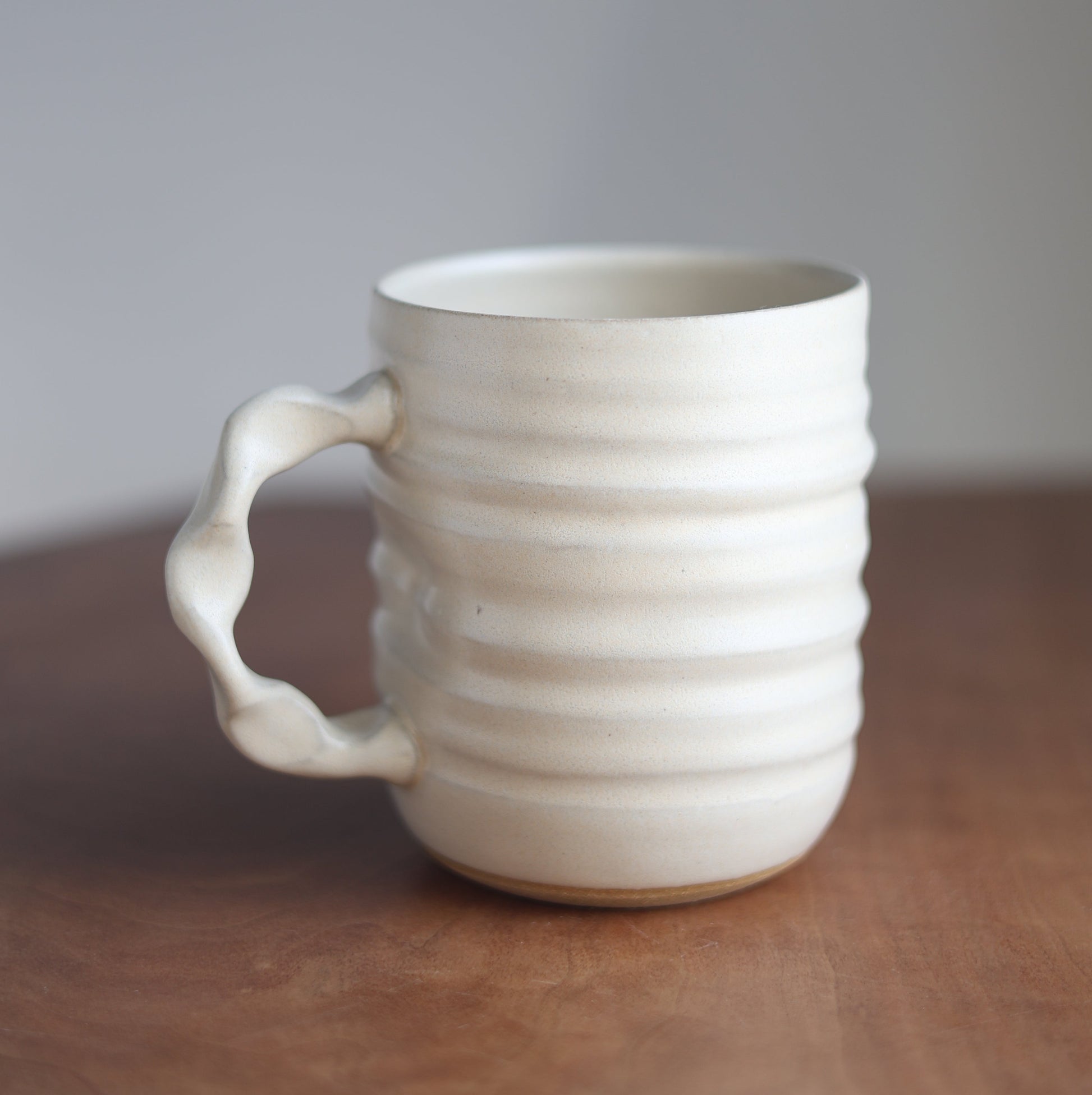 Cream Handmade ceramic jumbo companion mug with a handle on a wooden surface