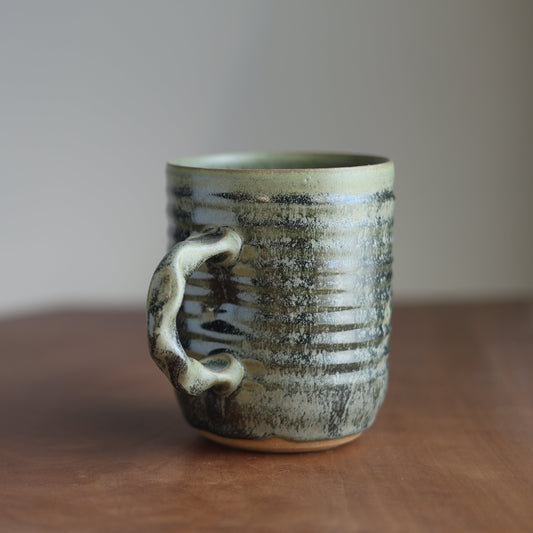 22 oz moss green Ceramic mug with a textured surface on a wooden table
