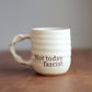 Cream ceramic companion mug with 'Not today fascist' text on a wooden surface.