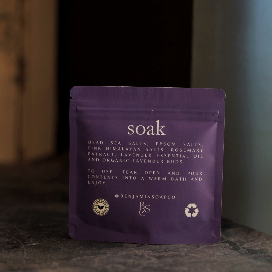 Purple packet labeled 'soak' on a dark surface with a blurred background