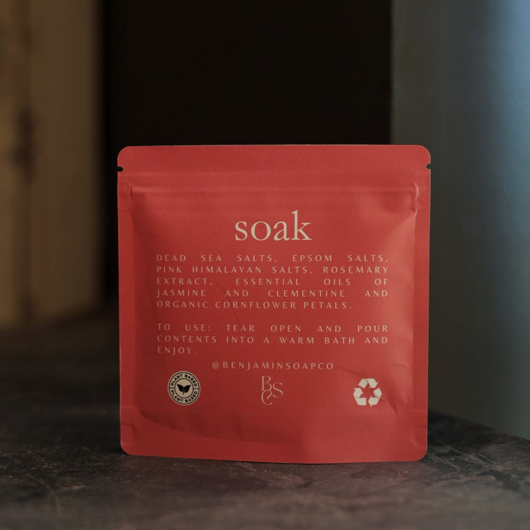 Coral packet of 'soak' on a dark surface with a blurred background