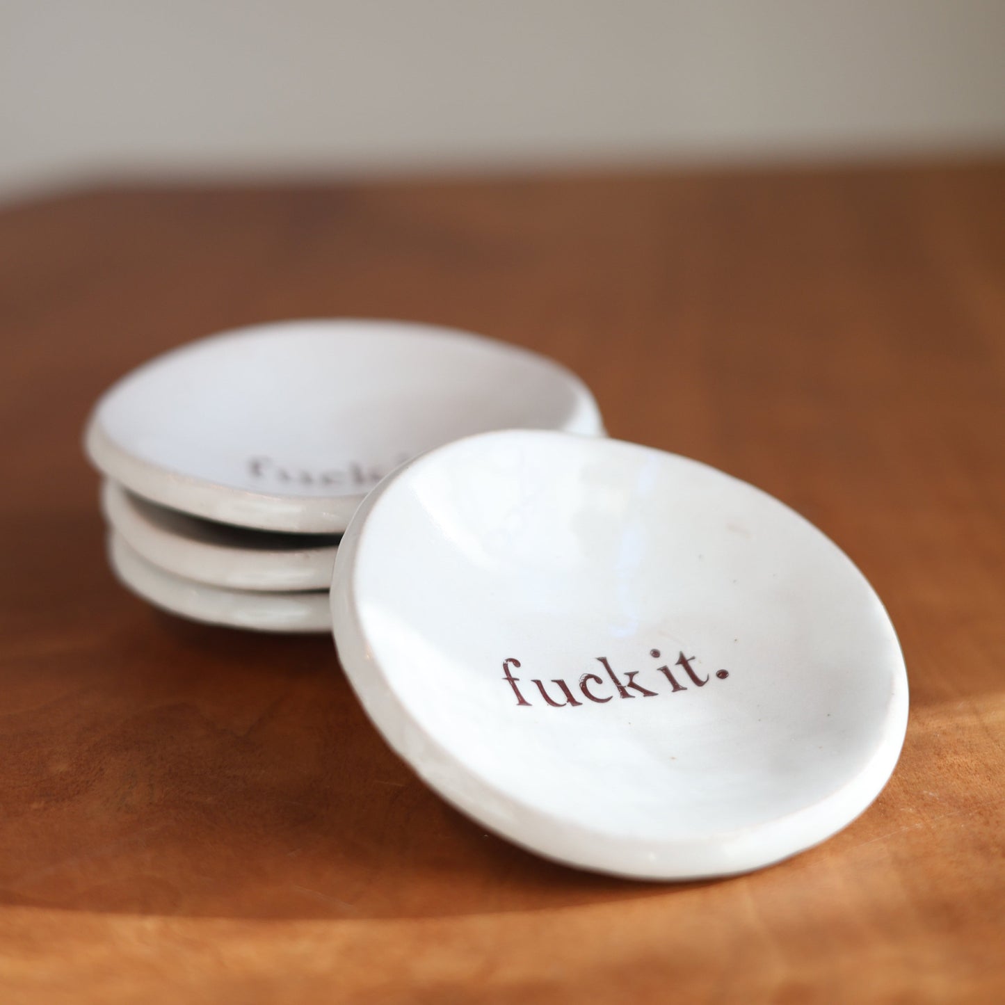 White ceramic trinket dish with "Fuck it" in the center in a hand drawn font
